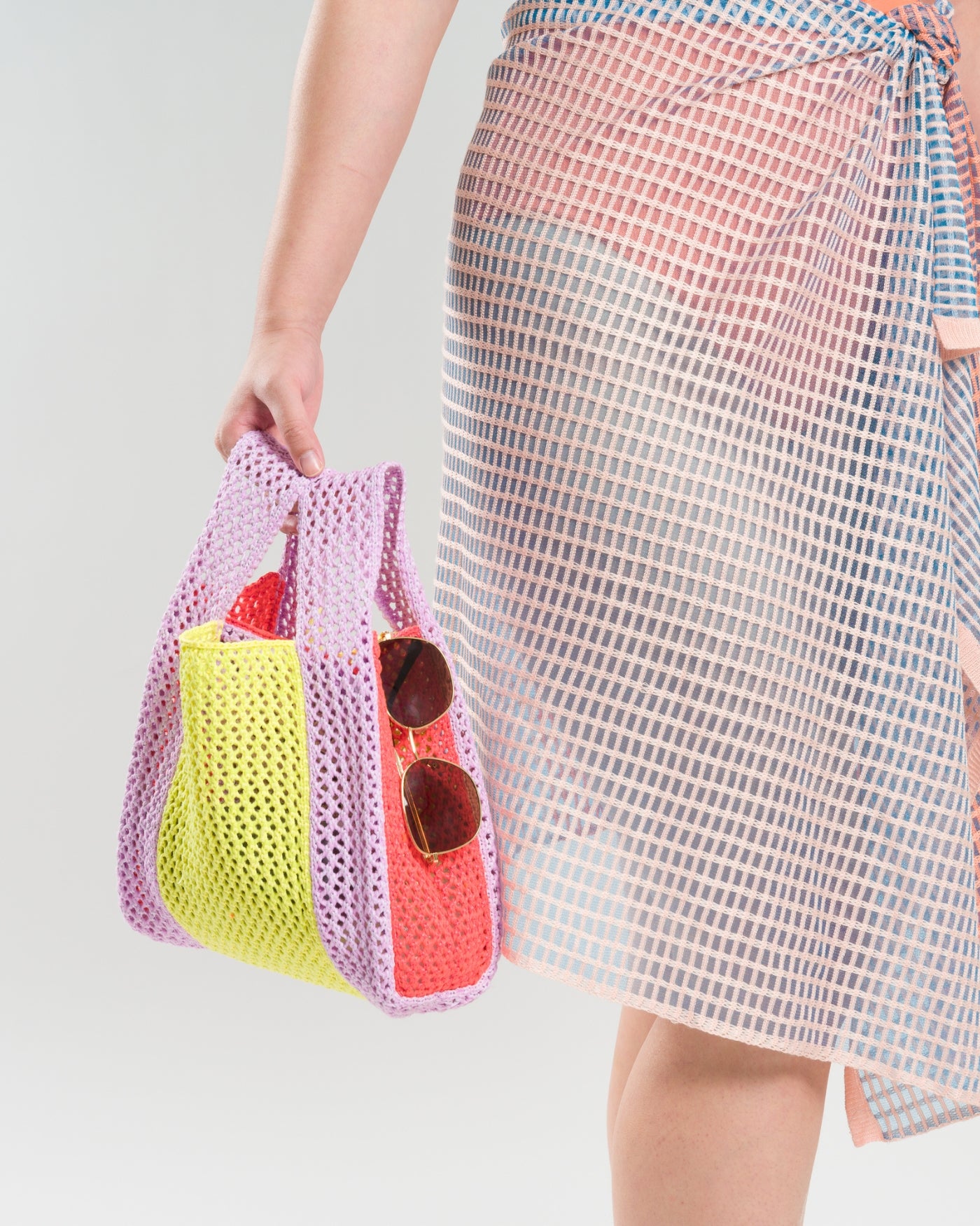 Colorblocked raffia crochet beach bag with sunglasses and open knit sarong
