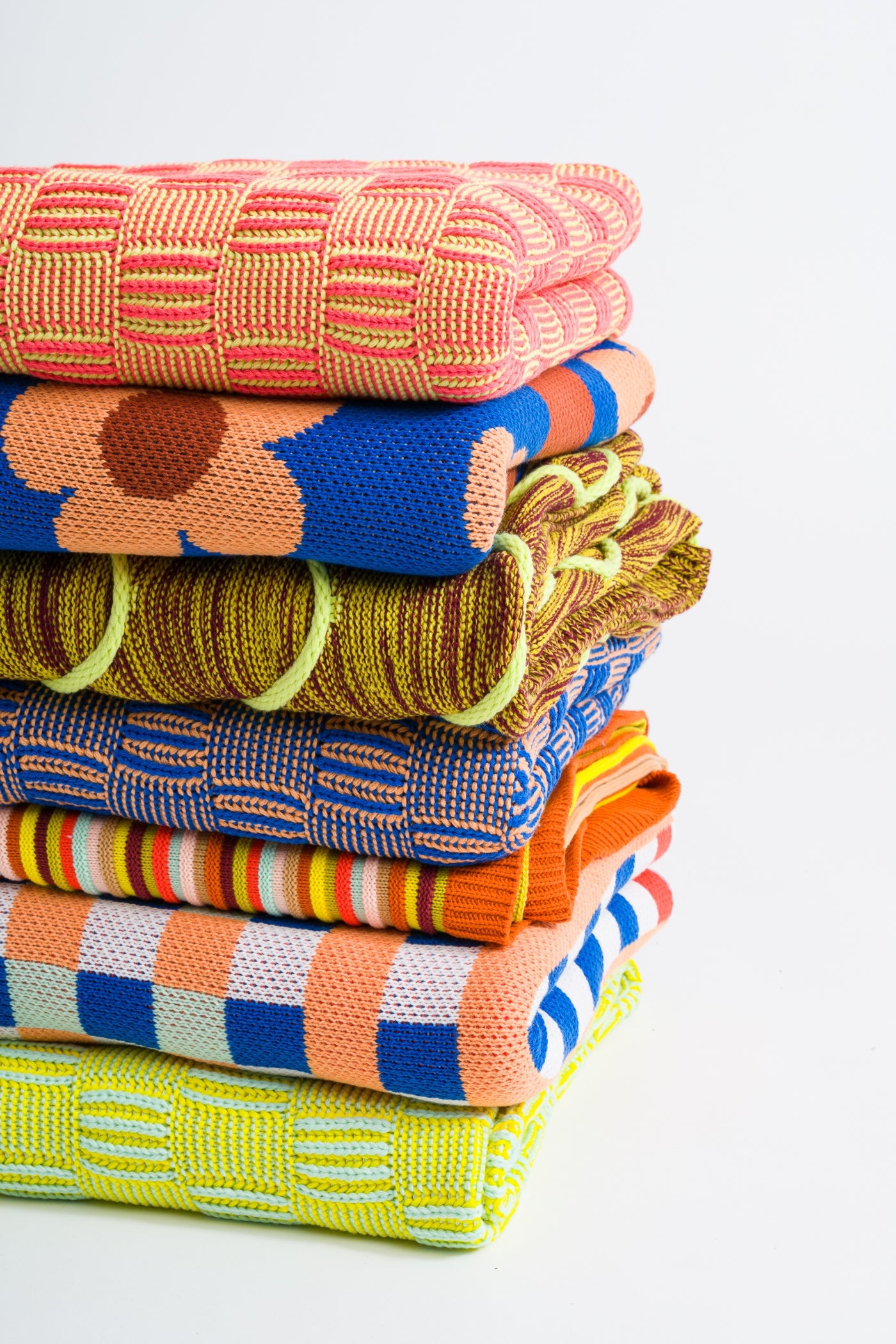 stack of colorful textured knit throw blankets