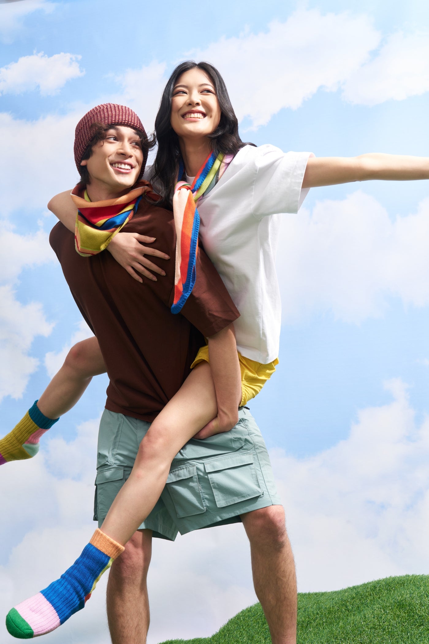 two models wearing matching striped knit triangle scarves