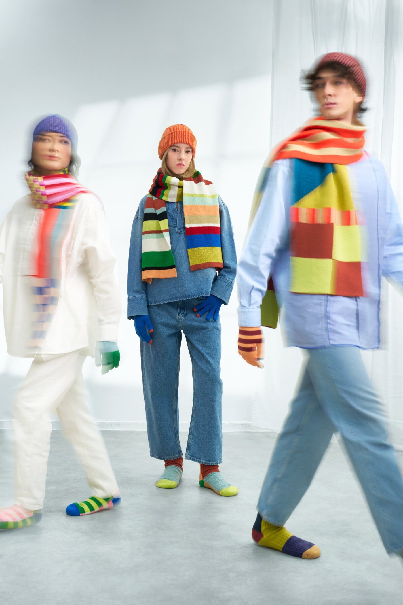 models wearing oversized bright knit scarves and house socks and beanies