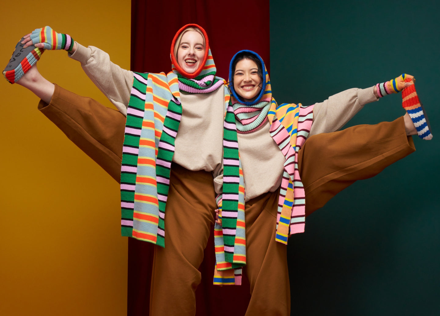 two models wearing matching zipper striped scarves hoods and knit slippers