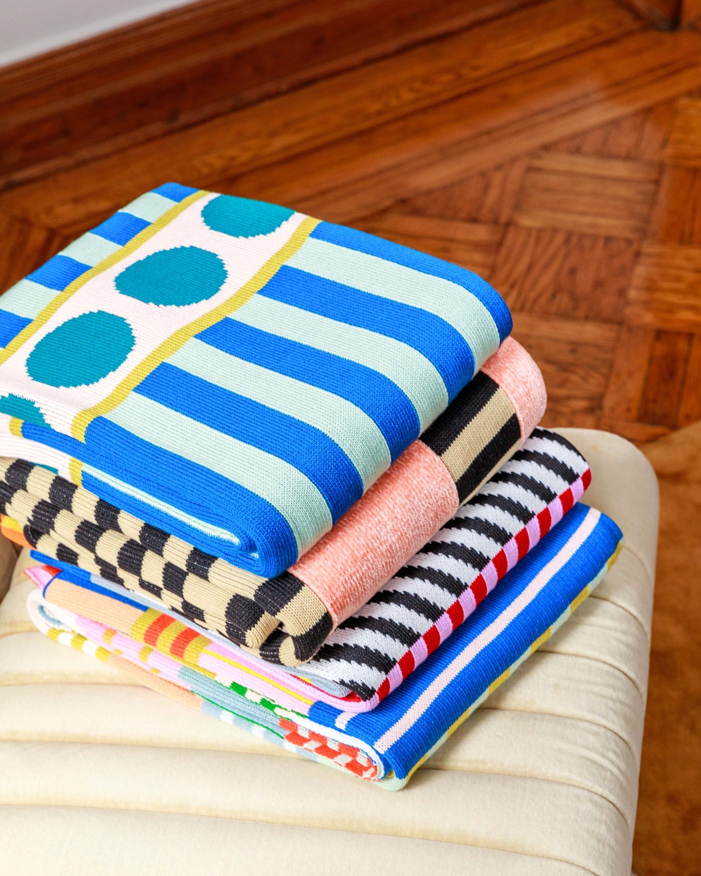 stack of bright knit throw blankets knit with deadstock yarn