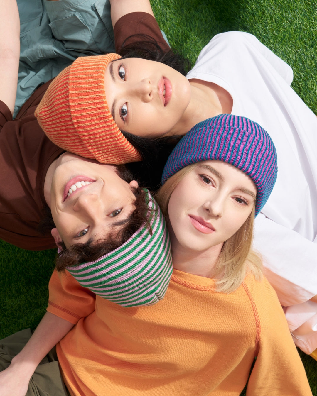 three models wearing colorful plush ribbed beanies