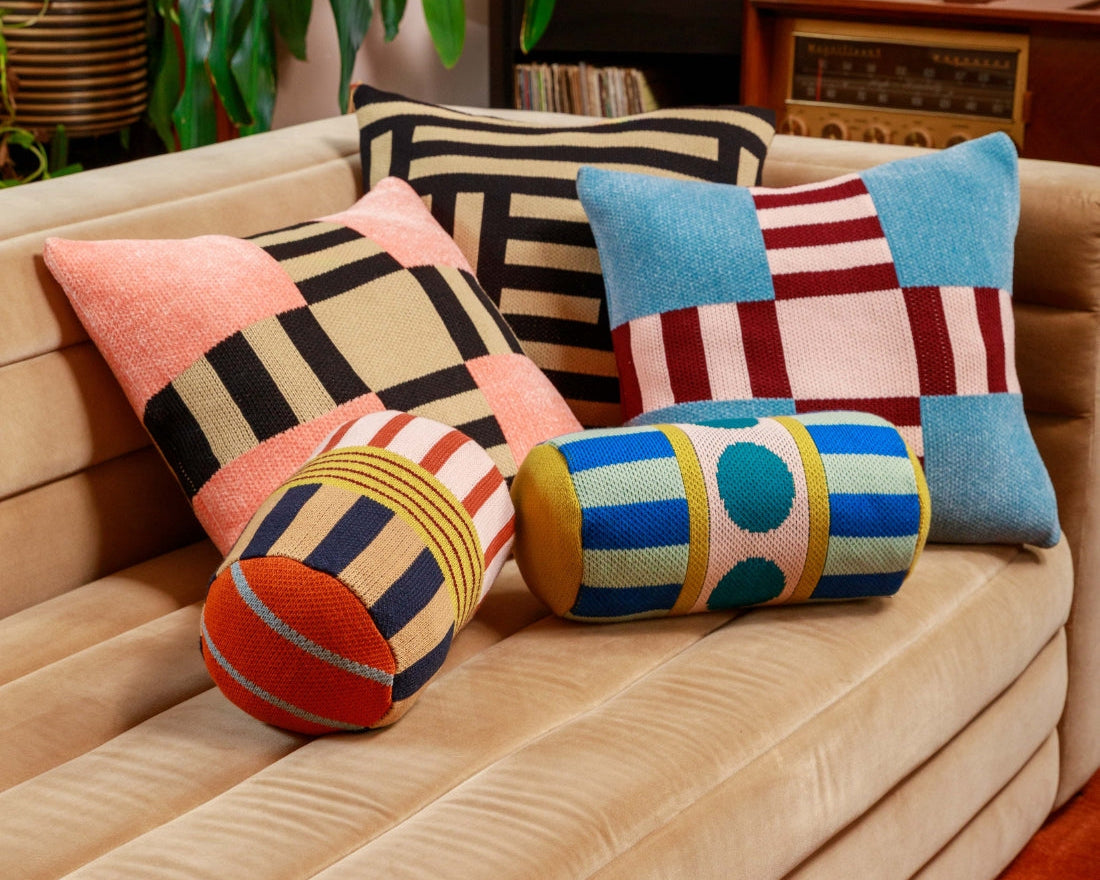 colorful knit pillows on a velvet couch