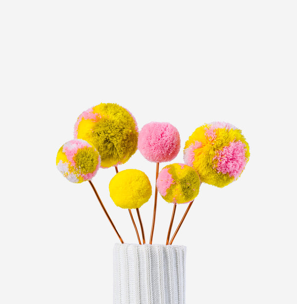 Yellow Pink | colored pom pom flower bouquet in a knitted vase with a white background